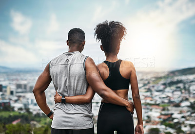 Buy stock photo Rearview shot of an unrecognizable sporty young couple standing with their arms around one another outdoors