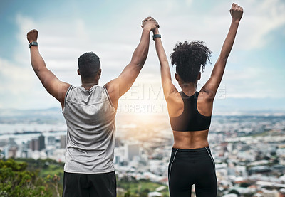 Buy stock photo Rearview shot of an unrecognizable young couple cheering in celebration outside