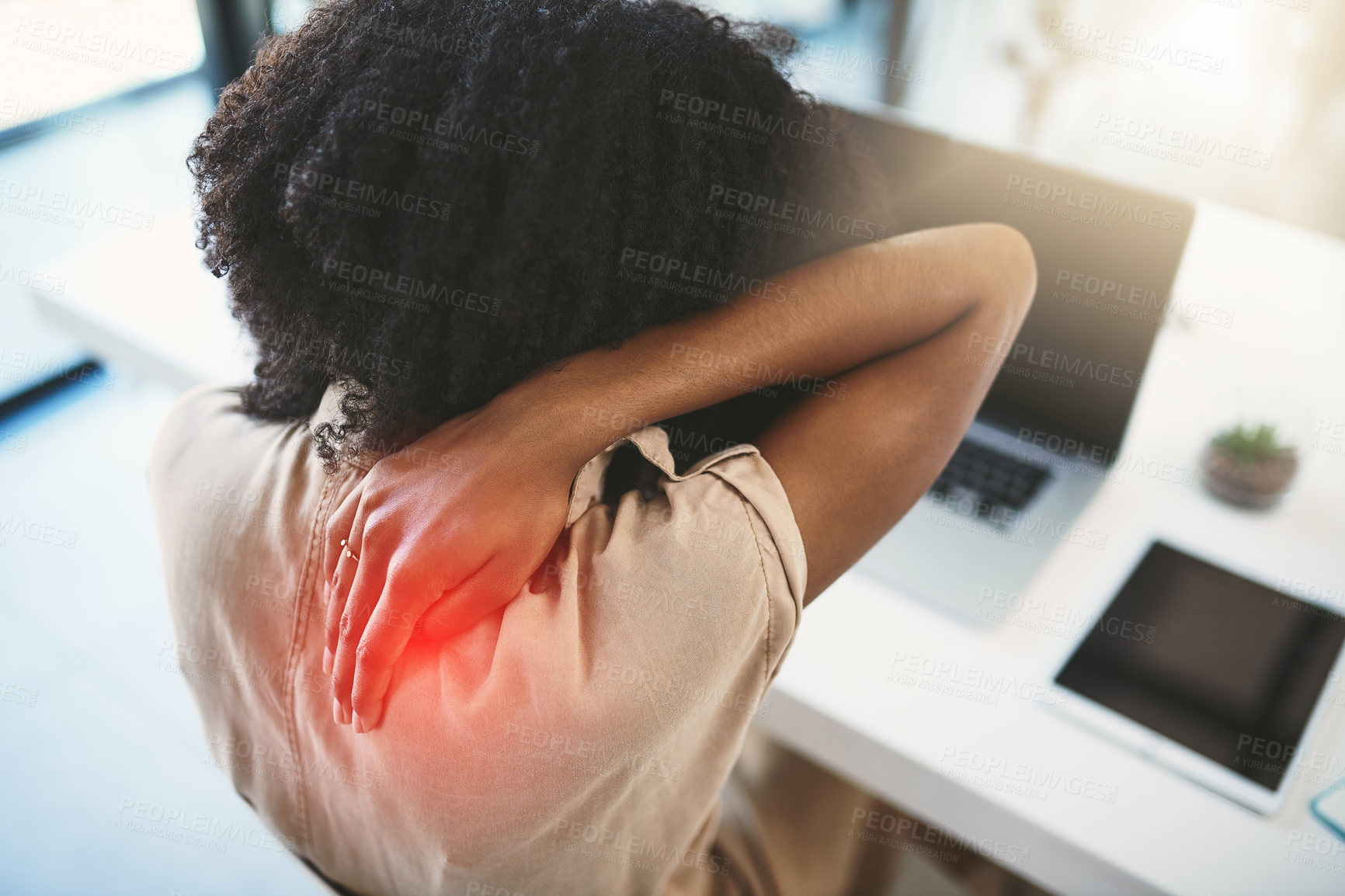 Buy stock photo Shot of a young businesswoman experiencing back pain while working in a modern office