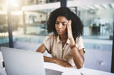 Buy stock photo Shot of a young businesswoman looking stressed at her desk in a modern office