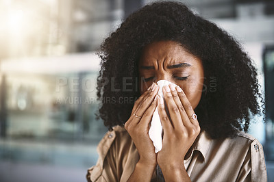 Buy stock photo Shot of a young businesswoman blowing her nose with a tissue while working in a modern office