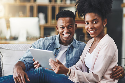 Buy stock photo Shot of a happy young couple using a digital tablet together on the sofa at home
