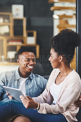 Buy stock photo Shot of a happy young couple using a digital tablet together on the sofa at home