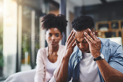 Buy stock photo Couple, man and headache from stress with conflict for cheating, betrayal and affair with fight or breakup in home. Black people, migraine and toxic marriage in lounge with disagreement and argument