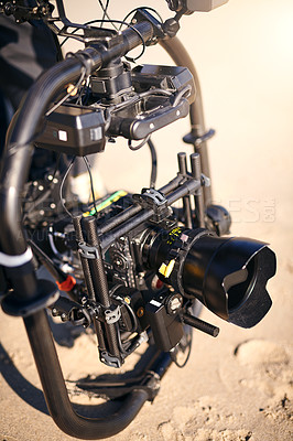 Buy stock photo Closeup of a state of the art video camera placed on the ground at a beach during the day