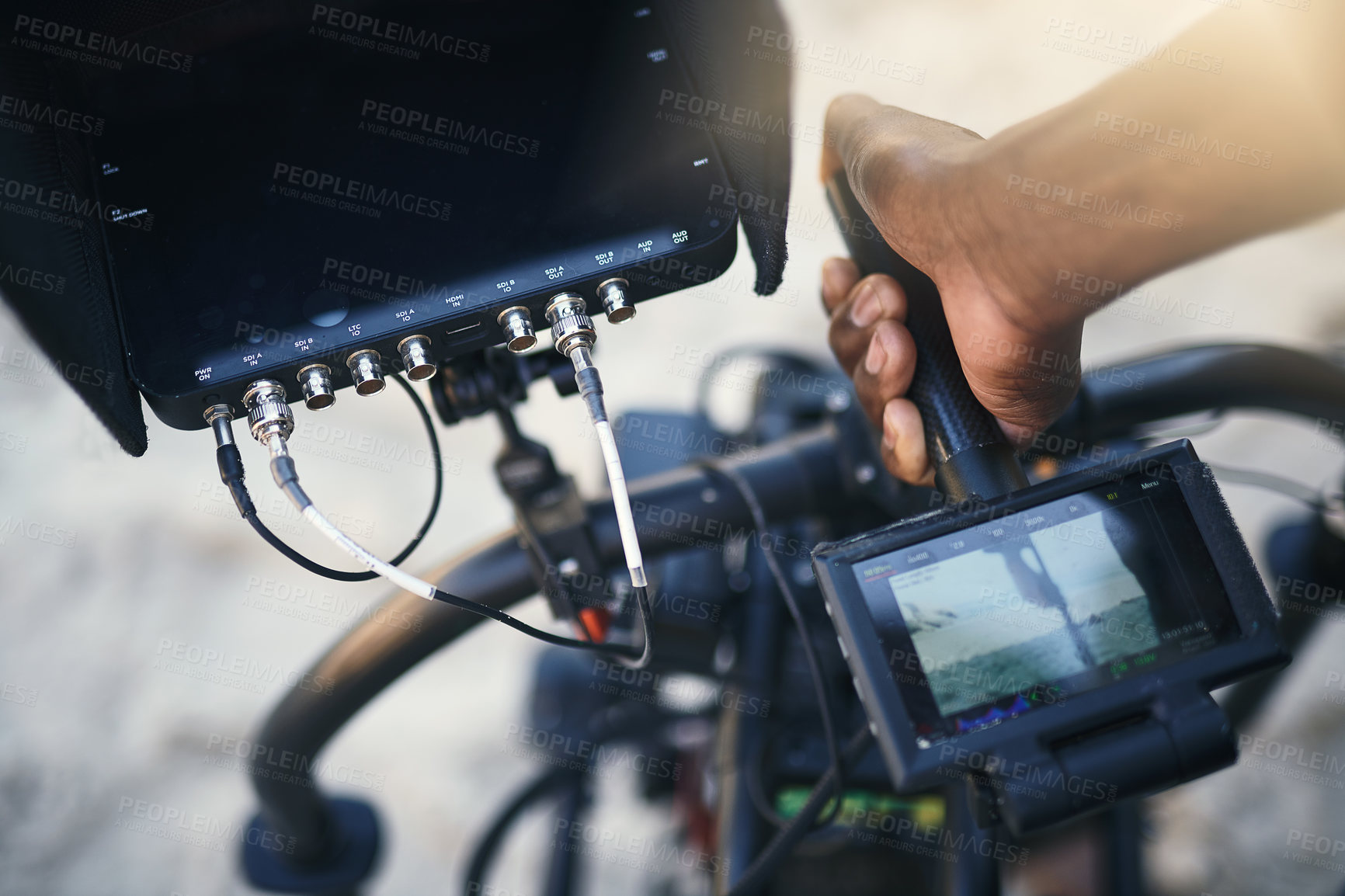 Buy stock photo Closeup of an unrecognizable person holding a state of the art video camera outside on a beach during the day