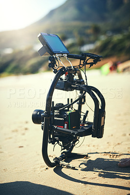 Buy stock photo Shot of a state of the art video camera placed on the ground at a beach during the day