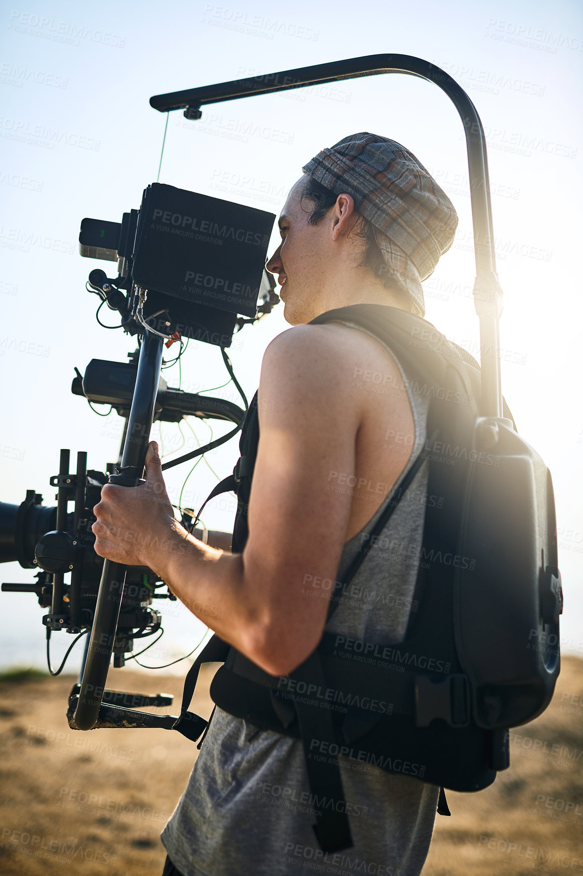 Buy stock photo Videographer, man and video camera outdoor for movie, professional production or travel documentary. Cameraman, recording and shooting in nature with equipment for creative filmmaking at beach on set