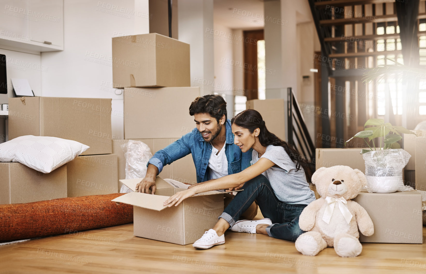 Buy stock photo Happy couple, moving in or unpacking with box at new home for renovation, relocation or property investment. Excited man, woman or tenant owners with smile for unboxing on floor at apartment building