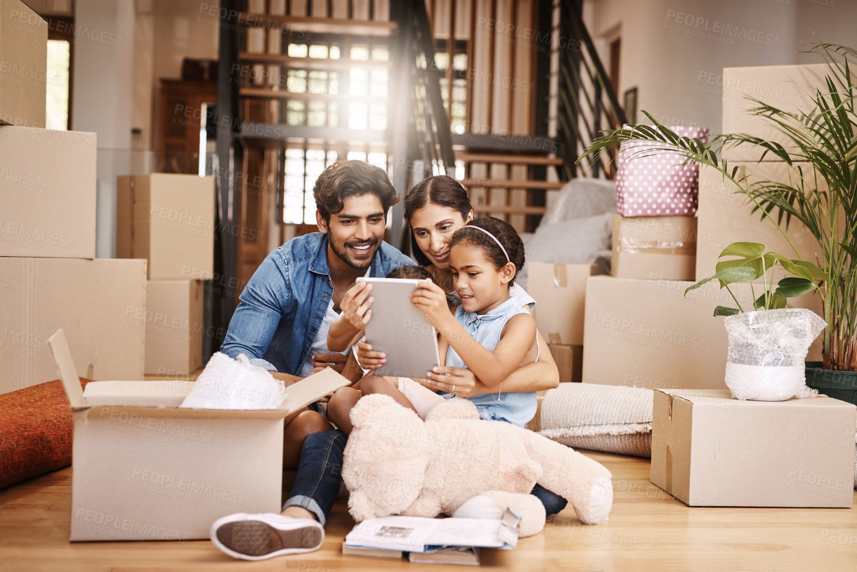 Buy stock photo Full length shot of an affectionate young family unpacking their boxes on moving day