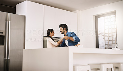 Buy stock photo Cropped shot of an affectionate young couple dancing in their kitchen at home