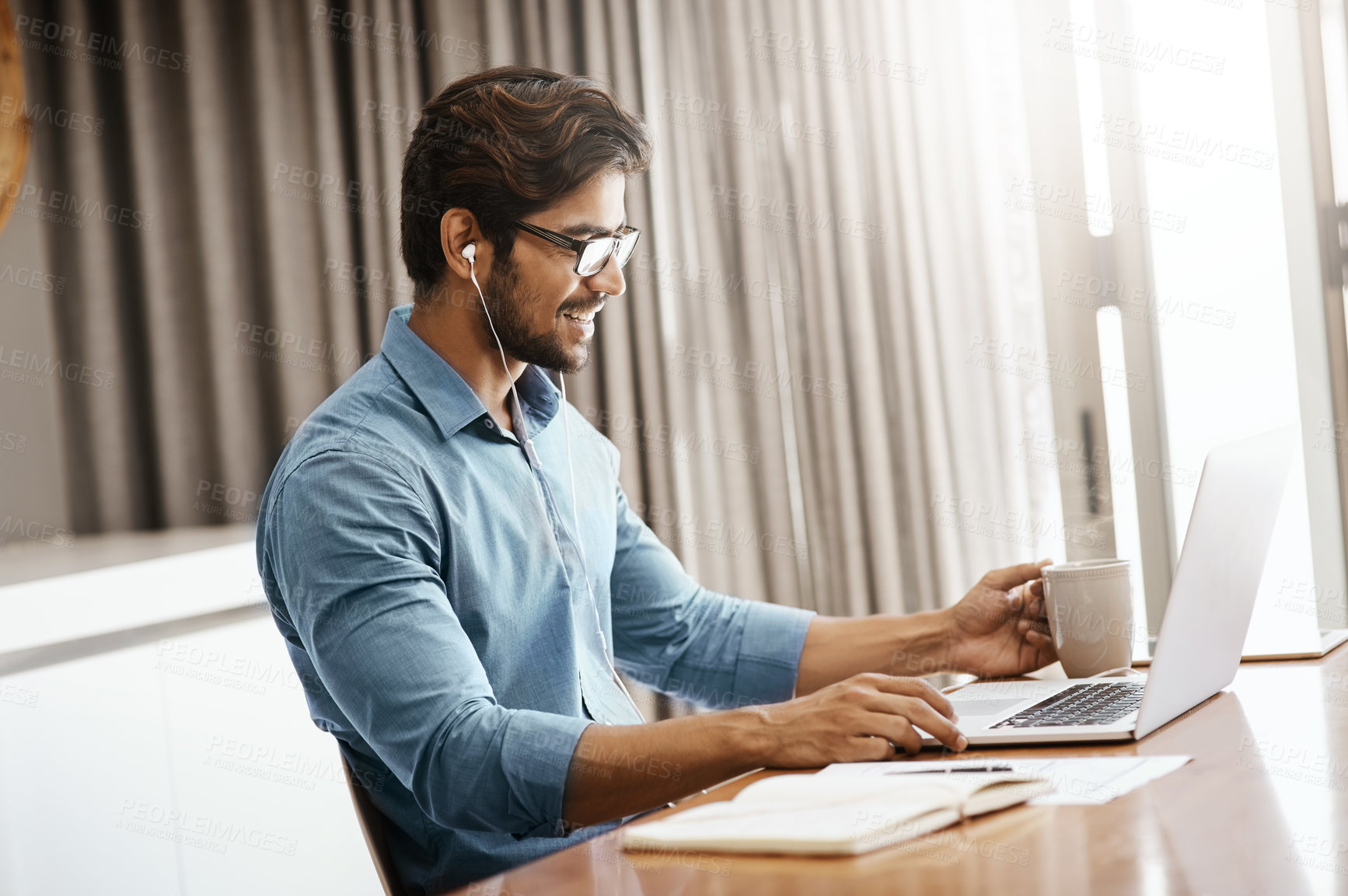 Buy stock photo Cropped shot of a handsome young businessman working on his laptop in the office at home