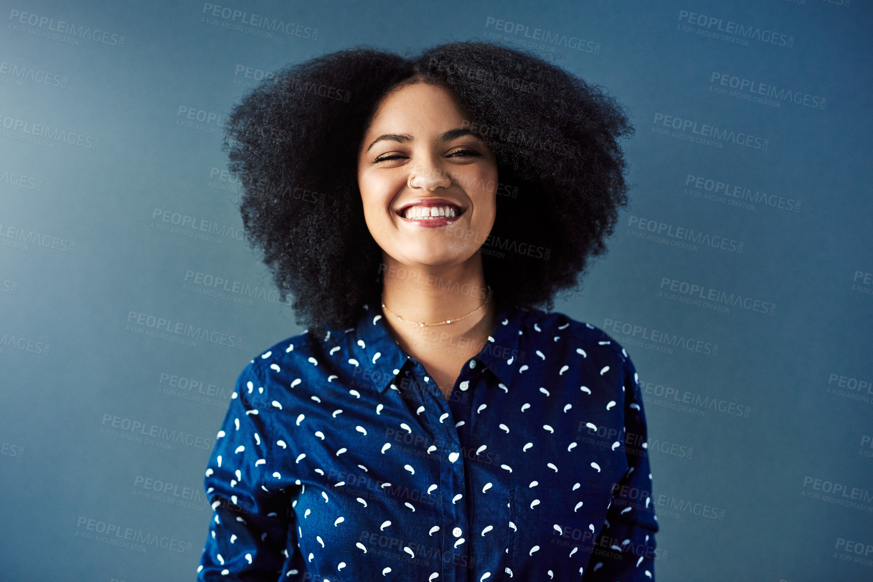 Buy stock photo Studio portrait of an attractive young woman against a blue background
