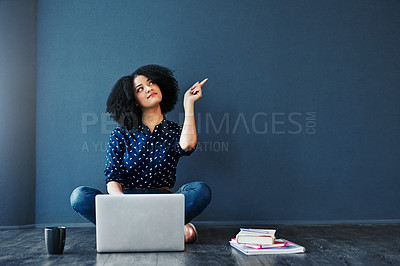 Buy stock photo Studio shot of an attractive young woman looking thoughtful while using a laptop against a blue background