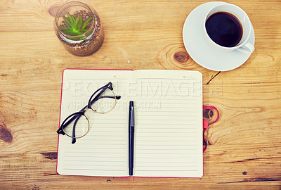Buy stock photo High angle shot of a notebook and other various tools at a workstation