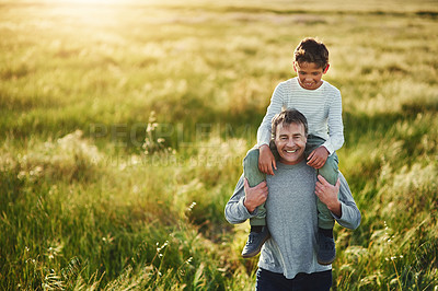 Buy stock photo Shot of a father carrying his son on his shoulders outdoors