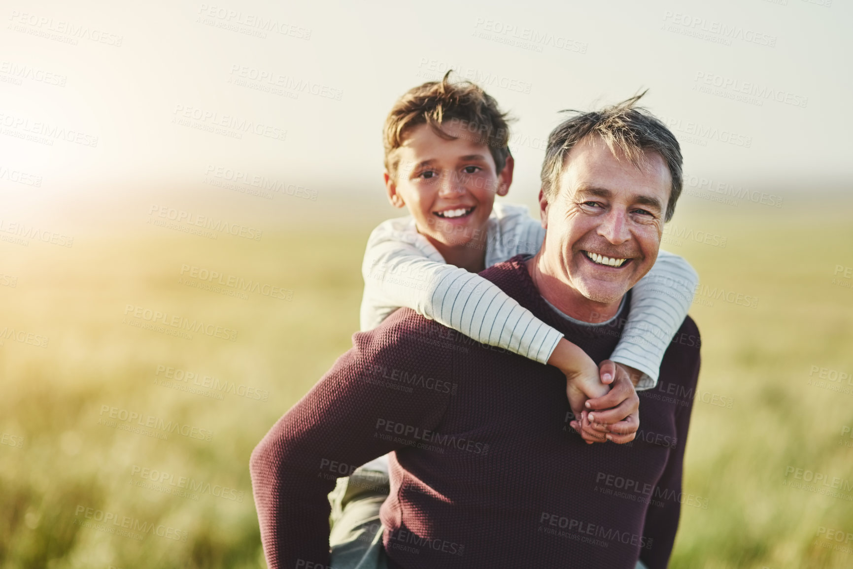 Buy stock photo Portrait, father and carrying of son in nature, outdoor and smile for family in space, sunshine or grass. Countryside, dad and visit of Texas with boy for fresh air, man or bonding with child in farm