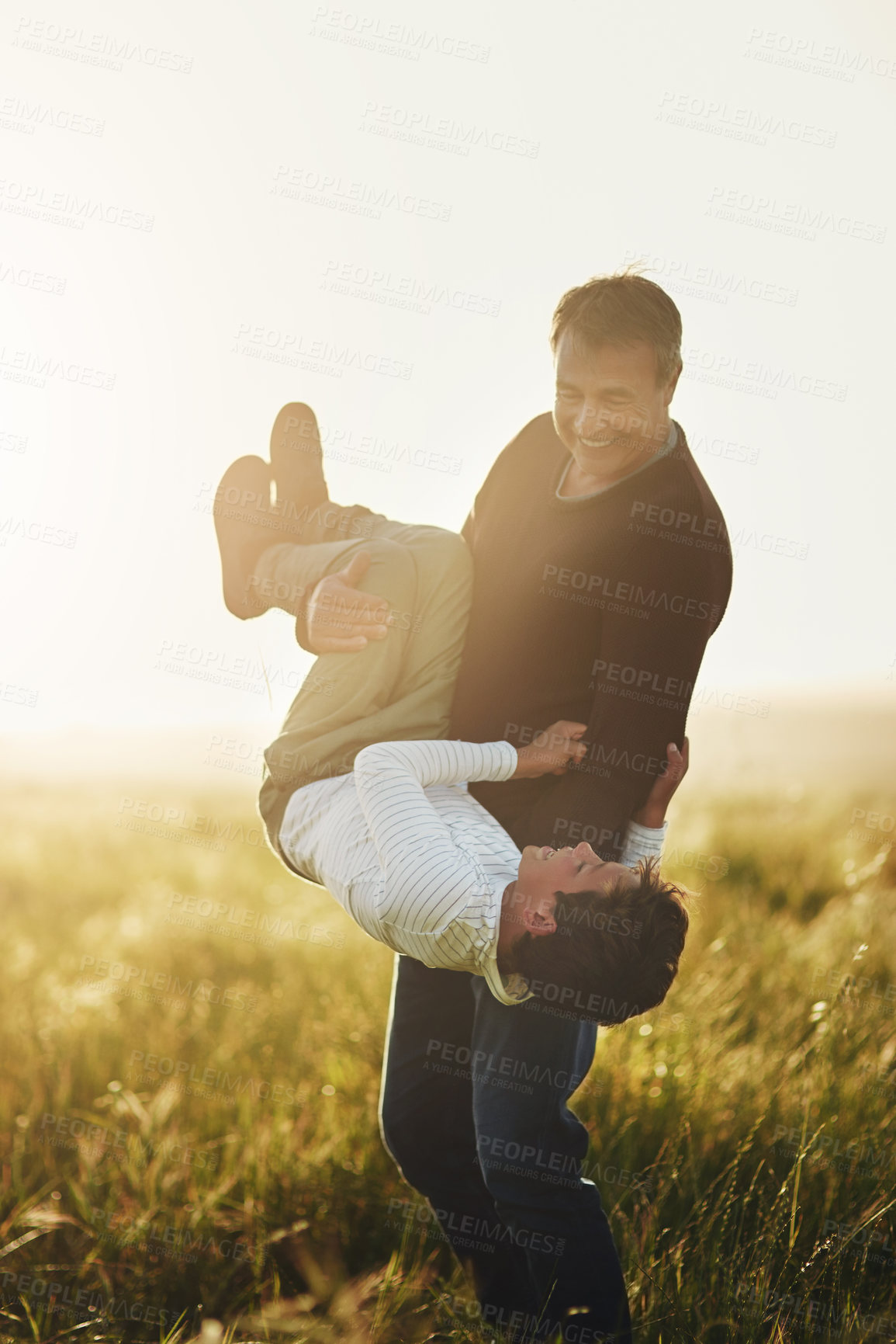 Buy stock photo Playful, dad and carrying child by field with laugh for outdoor adventure, goofy and bonding together. Happy, father and son with smile in nature for funny, humor and love on holiday in Australia