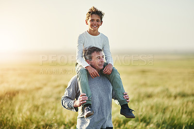 Buy stock photo Shot of a father carrying his son on his shoulders outdoors