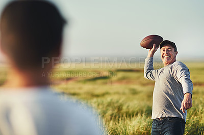 Buy stock photo Shot of father throwing a football to his son on a field