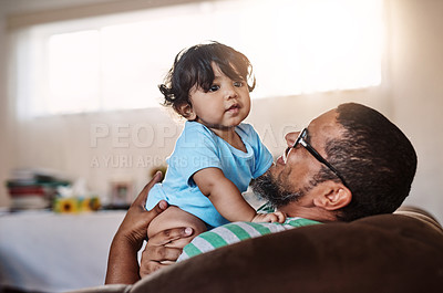 Buy stock photo Shot of a cheerful little boy being held by his father inside at home during the day