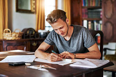 Buy stock photo Cropped shot of a young man working on a project at home