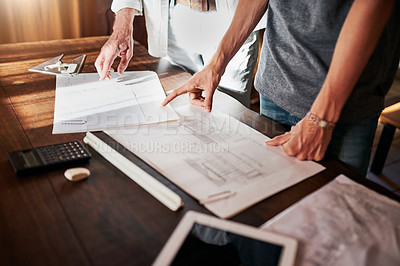 Buy stock photo Cropped shot of two unrecognizable men working on a blueprint together