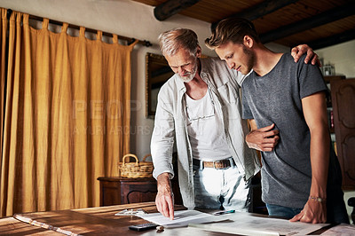 Buy stock photo Shot of two men working on a project together at home