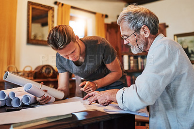 Buy stock photo Shot of two men working on a project together at home