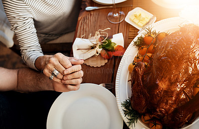 Buy stock photo High angle shot of an unrecognizable family saying grace at the dining table on Thanksgiving