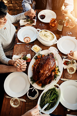 Buy stock photo Food, celebration and people praying and holding hands at a table together for thanksgiving holiday. Above group of family or friends pray for gratitude for healthy lunch, turkey and wine in house