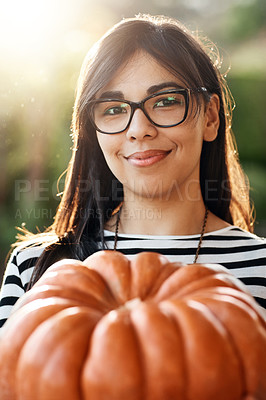 Buy stock photo Cropped portrait of an attractive young woman holding a pumpkin outside