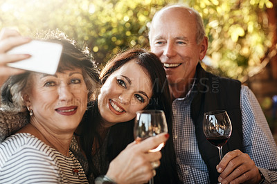 Buy stock photo Cropped shot of an attractive young woman taking a selfie with her parents on Thanksgiving