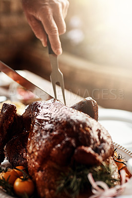 Buy stock photo Closeup shot of an unrecognizable man cutting into a roasted turkey on Thanksgiving