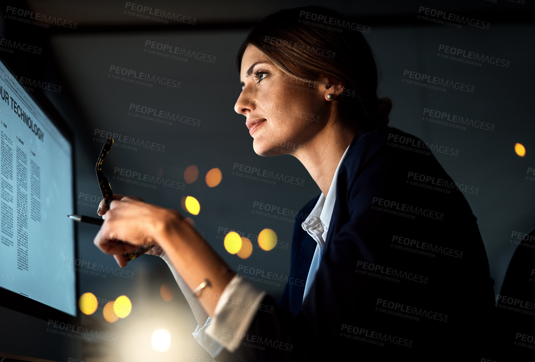 Buy stock photo Shot of a young businesswoman working late on a computer in an office