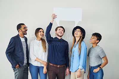 Buy stock photo Shot of a diverse group of creative employees holding up a speech bubble inside