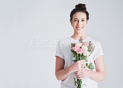 Buy stock photo Studio shot of a beautiful young woman holding a bouquet of flowers against a grey background