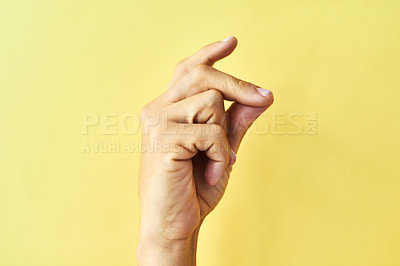 Buy stock photo Studio shot of an unrecognizable man snapping his fingers against a yellow background