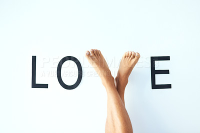 Buy stock photo  Love, word and feet of person with romantic, happiness and care sign of emotion gesture. Text, gratitude and legs of model for expression of connection, commitment or devotion by white background.