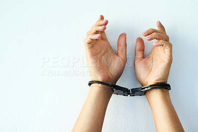 Buy stock photo Studio shot of an unrecognizable person's hands cuffed against a white background