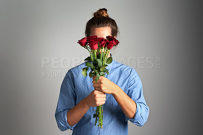 Buy stock photo Studio shot of an unrecognizable man holding flowers against a grey background