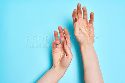 Buy stock photo Studio shot of an unrecognizable person's hands against a blue background