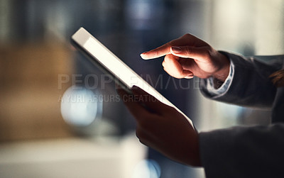 Buy stock photo Closeup of woman reading social media news on a digital tablet while working late in an office. Professional female browsing online, researching creative plans and strategies for a business project