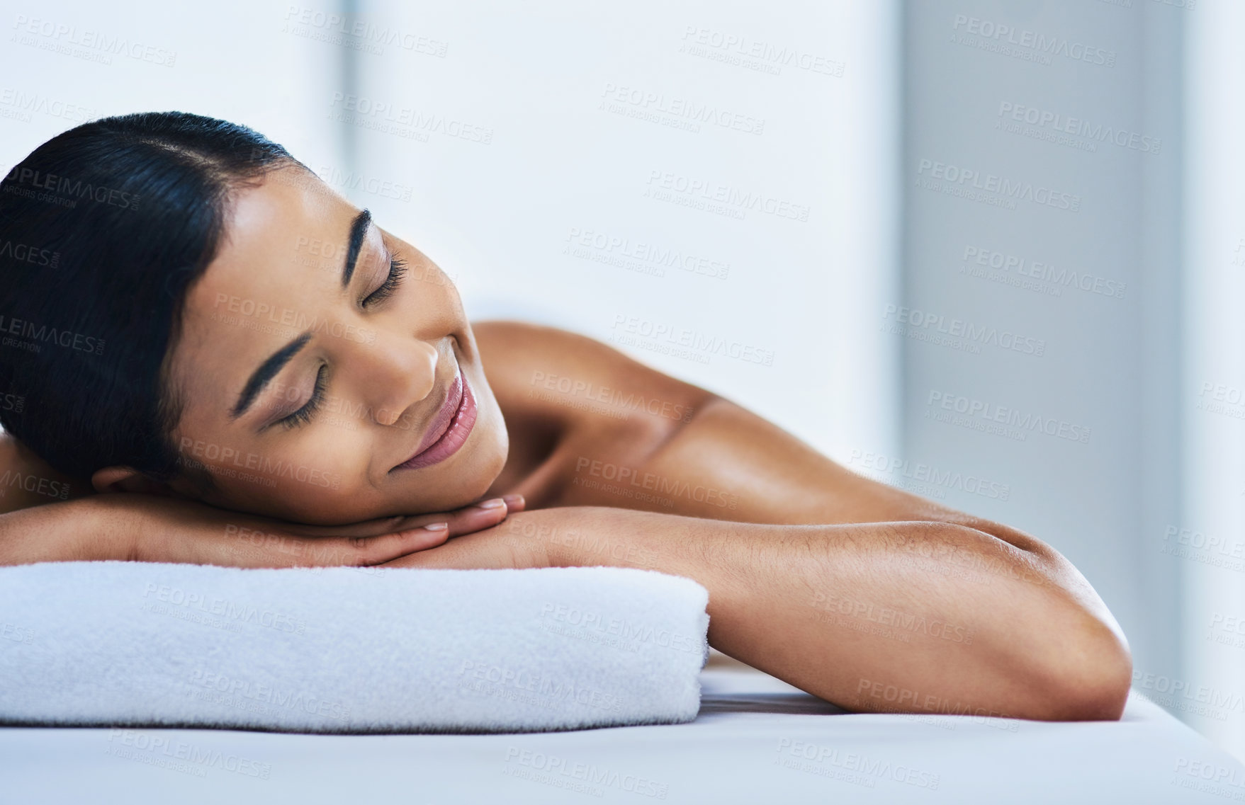 Buy stock photo Shot of a relaxed an cheerful young woman getting a massage indoors at a spa