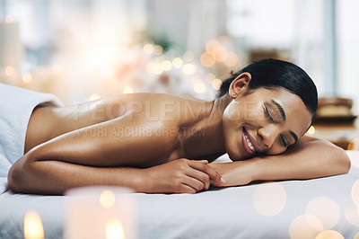 Buy stock photo Shot of a relaxed an cheerful young woman getting a massage indoors at a spa