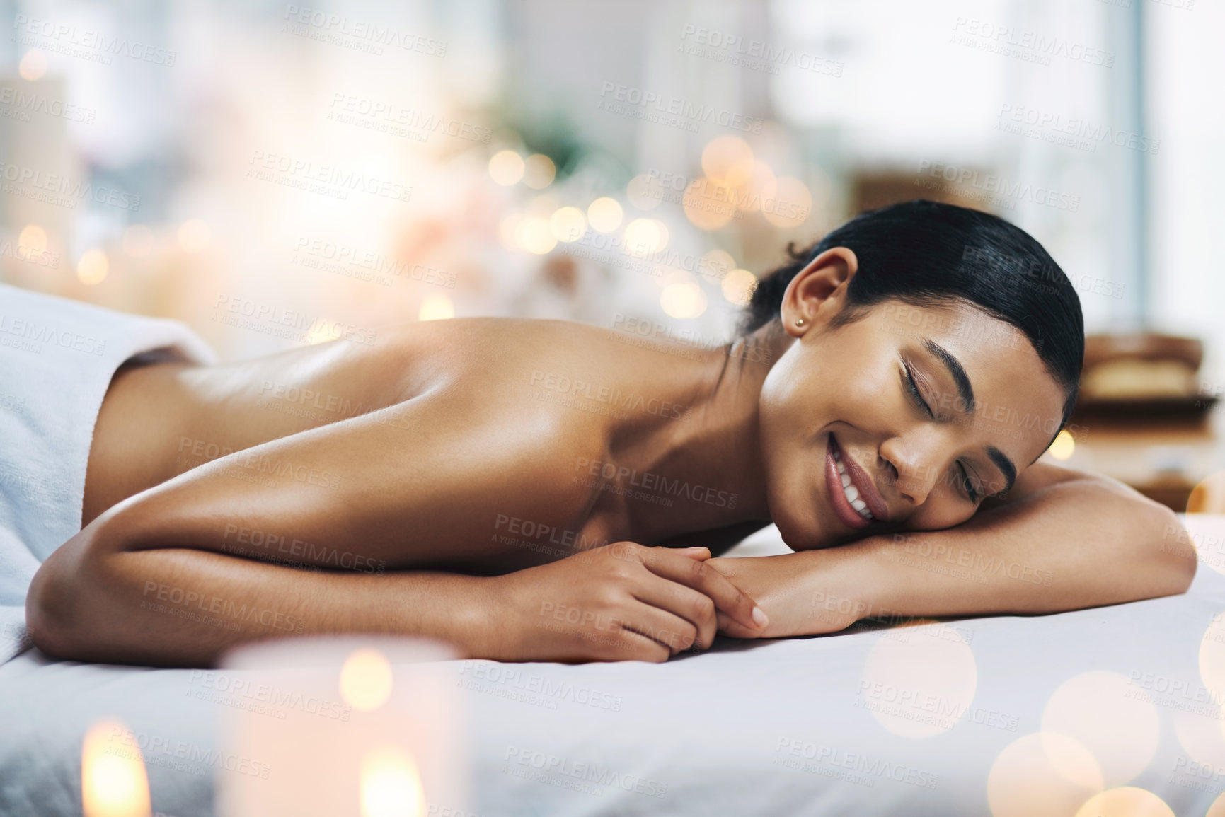 Buy stock photo Shot of a relaxed an cheerful young woman getting a massage indoors at a spa