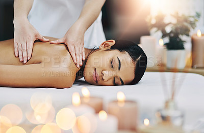 Buy stock photo Shot of a relaxed an cheerful young woman getting a massage indoors at a spa