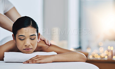 Buy stock photo Shot of a relaxed an cheerful young woman getting a massage indoors at a spa