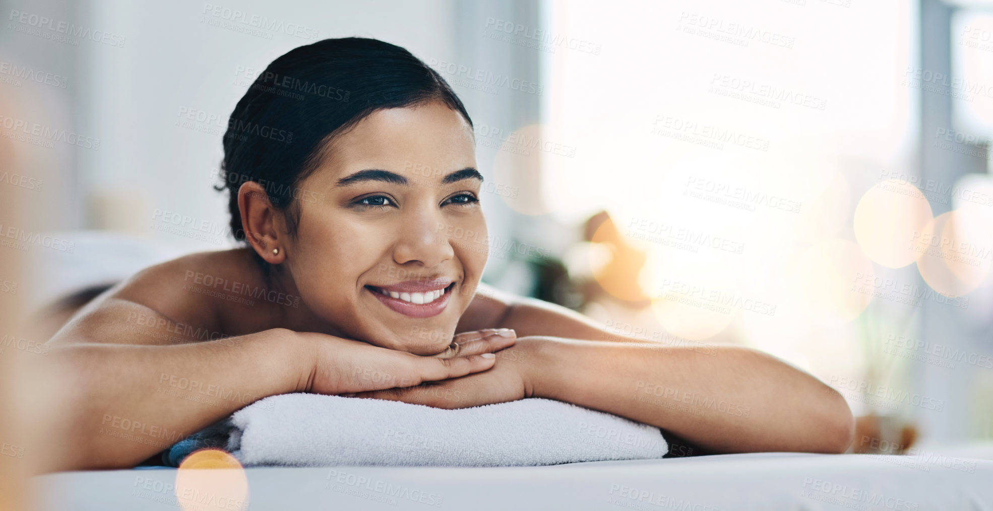 Buy stock photo Shot of a relaxed an cheerful young woman getting a massage indoors at a spa