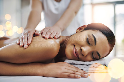 Buy stock photo Shot of a relaxed an cheerful young woman getting a massage indoors at a spa